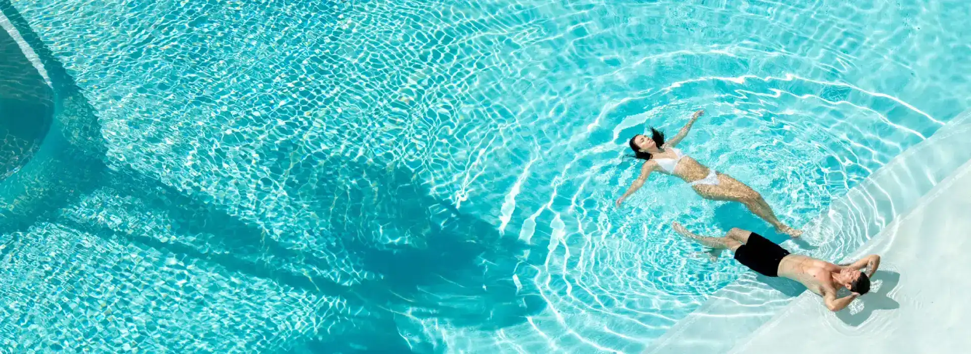 A couple enjoying a peaceful moment in a stunning turquoise pool.