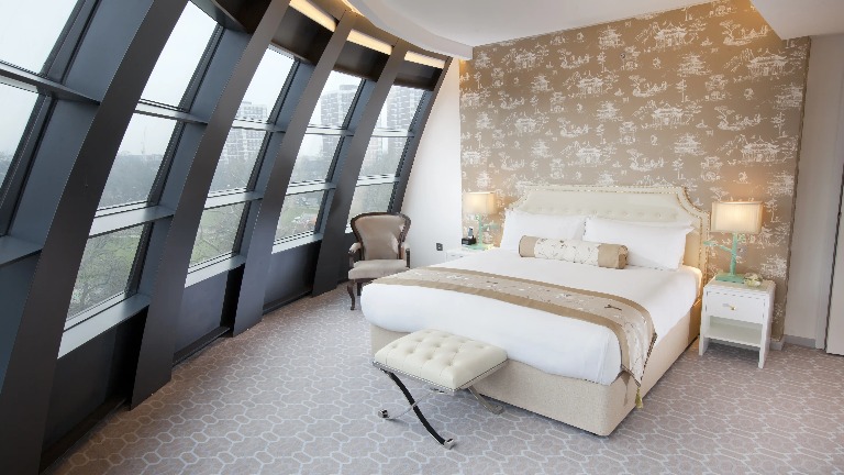 Bed and chair by the window in a Hotel room.